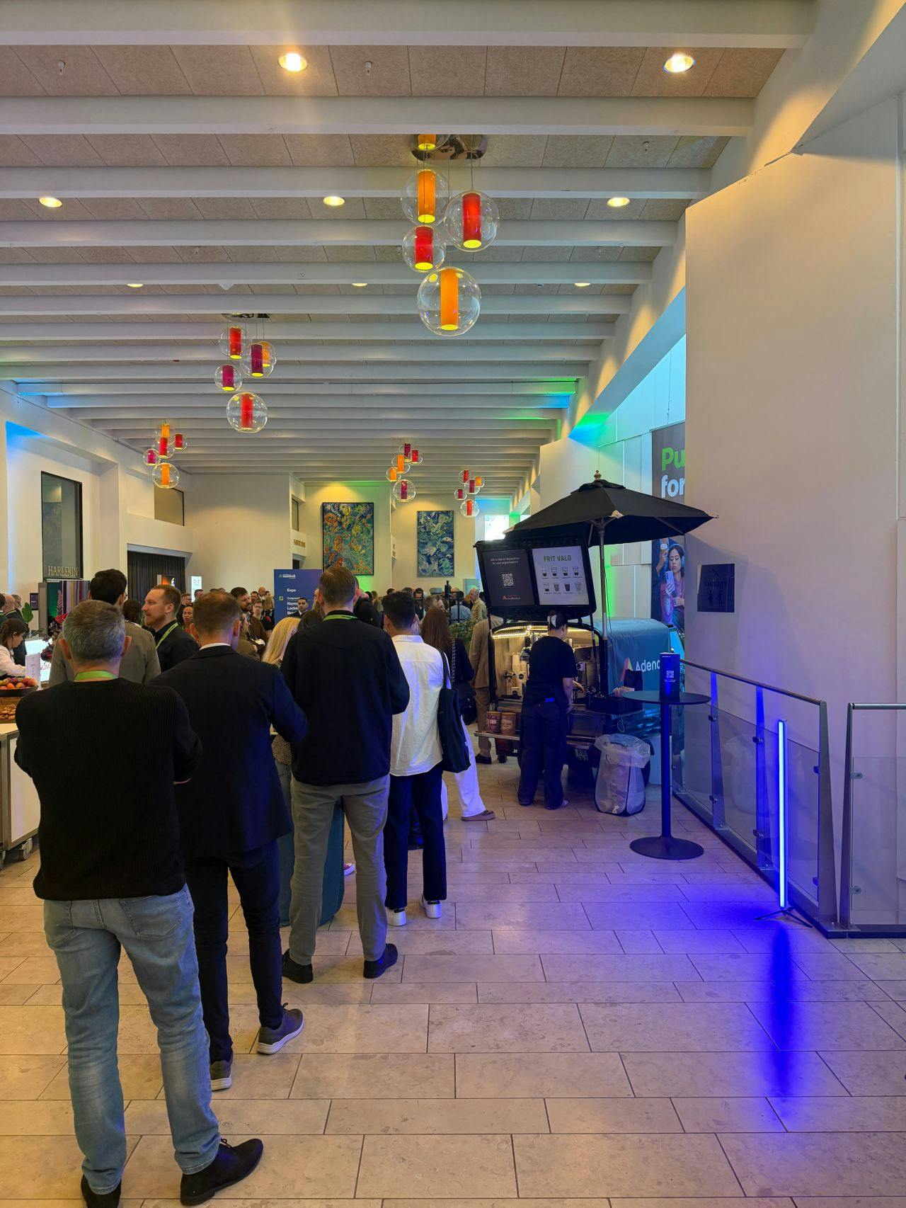Attendees queuing at an Adeno coffee station during a ServiceNow Summit.
