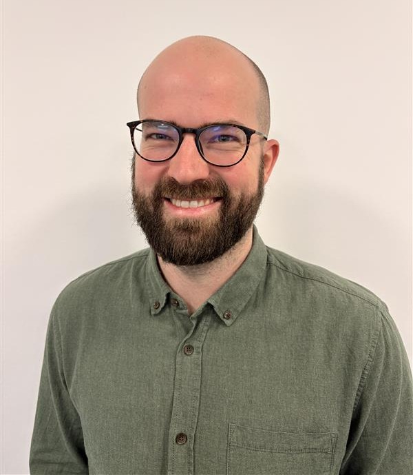 Portrait of Casper Barner, a ServiceNow professional, wearing glasses and a green shirt.