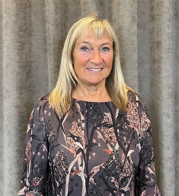 Portrait of Karin Vinther, a ServiceNow professional, standing in front of a grey curtain.