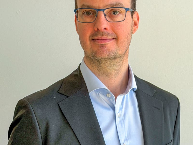 Portrait of Morten Kær Schøler, a ServiceNow professional, wearing a suit and glasses.