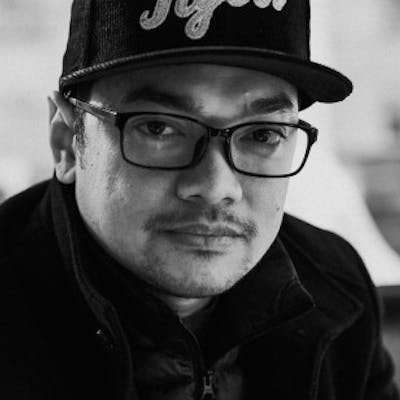 Black and white portrait of Zander Croox, a ServiceNow Platform owner, wearing glasses and a Tigers baseball cap.
