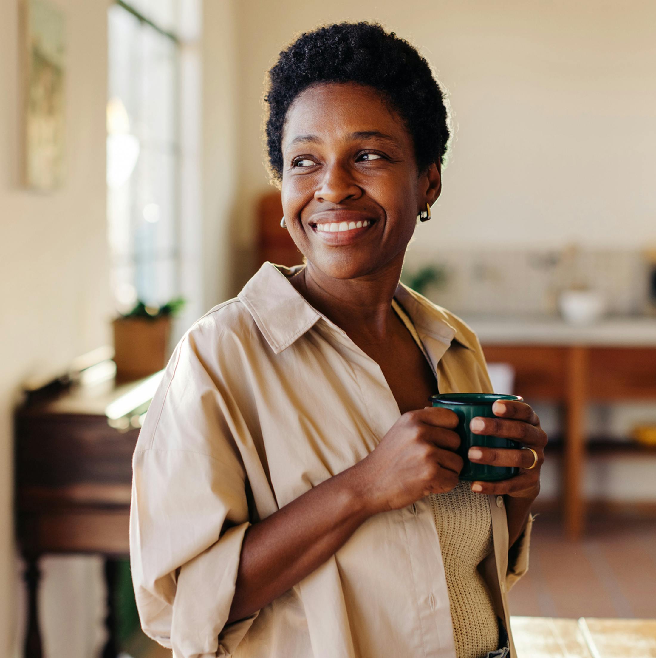 Women smiling holding mug