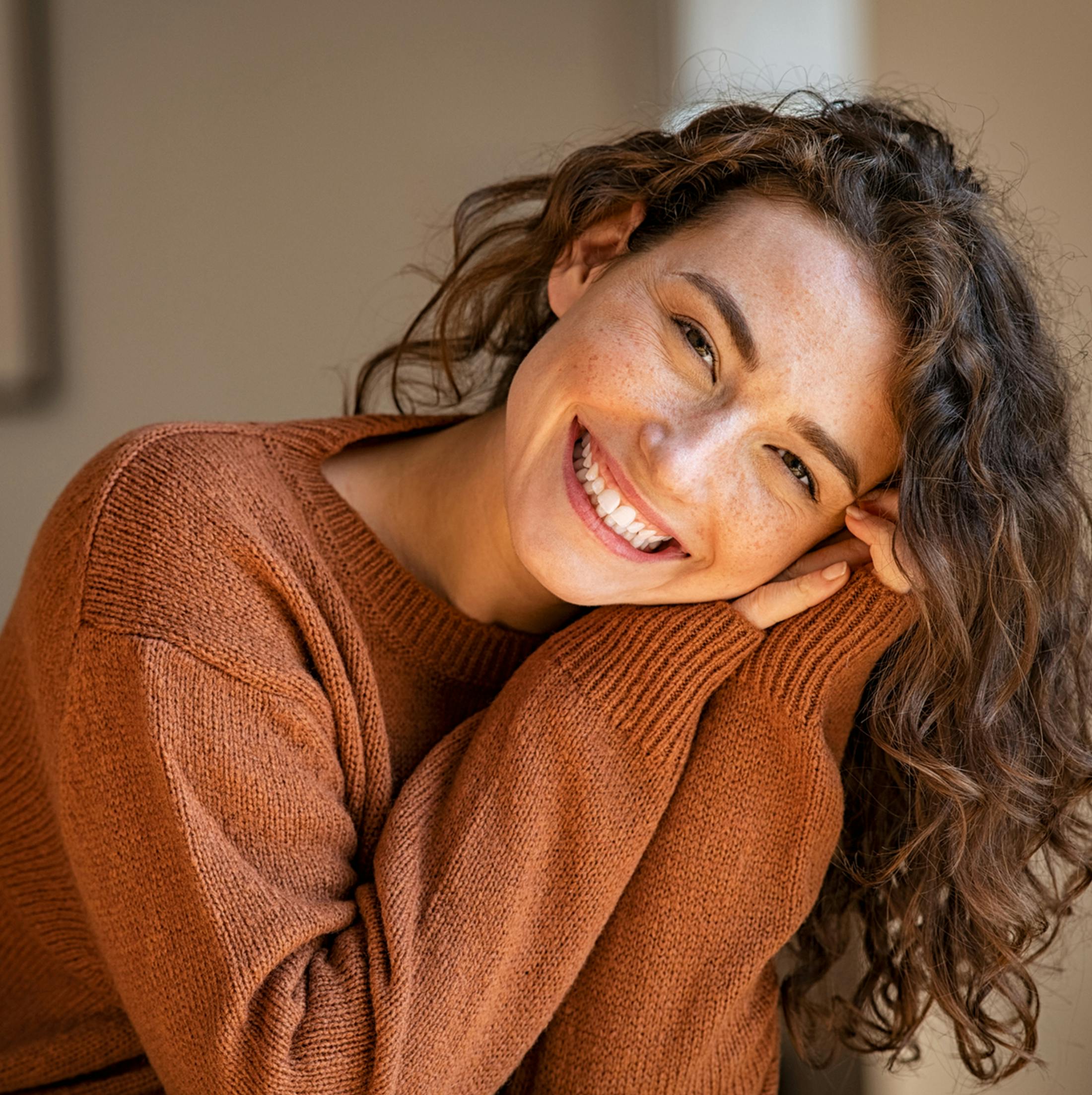 Women smiling with hands on face
