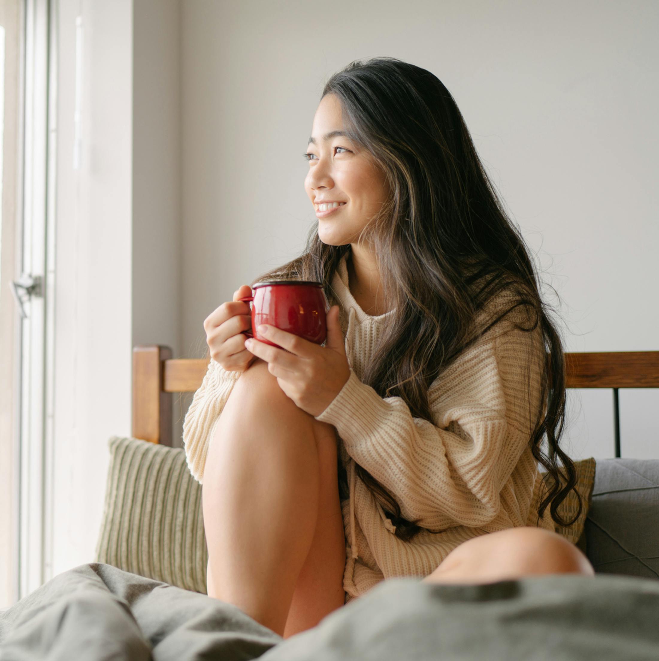 Women holding mug on couch