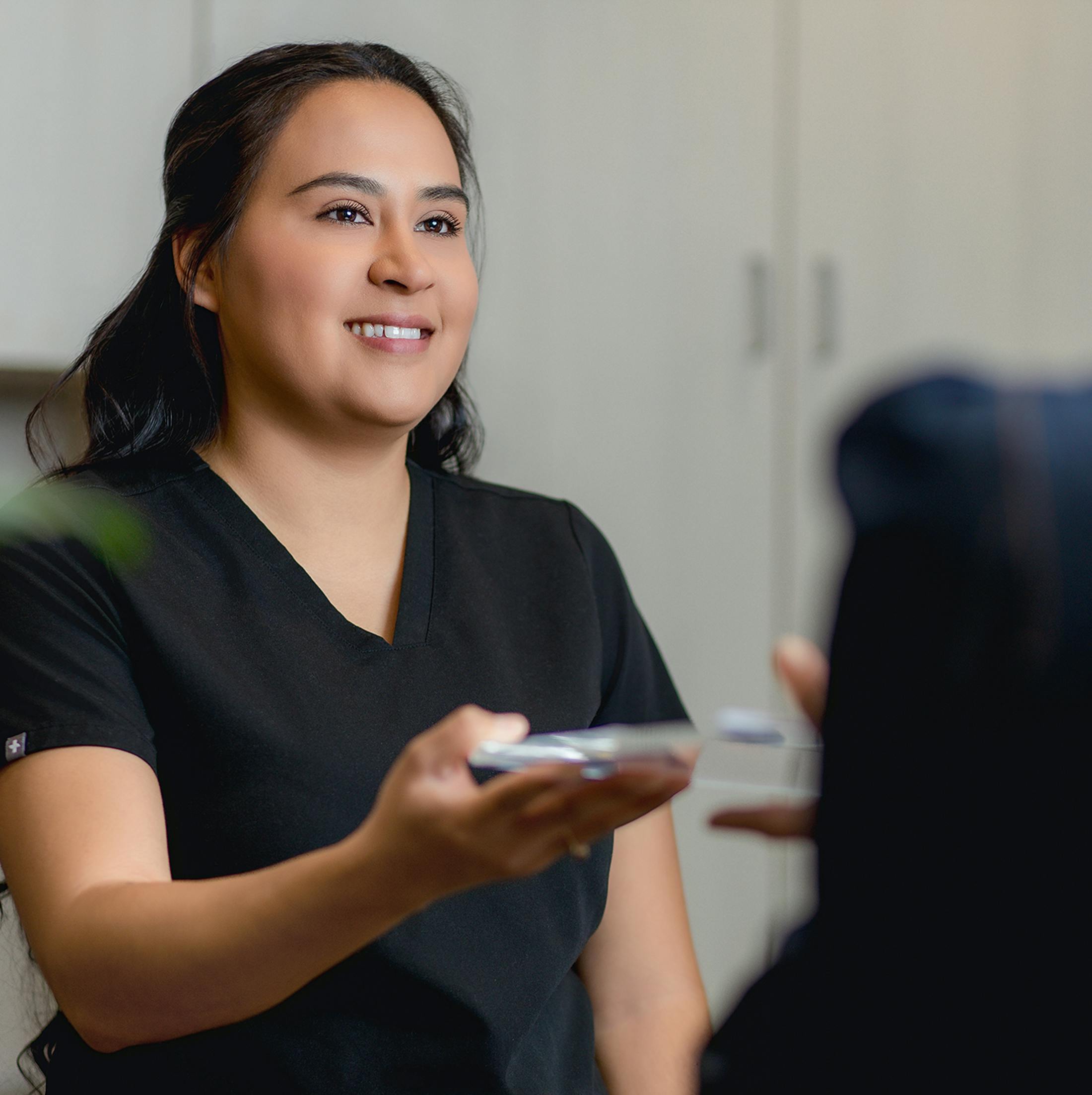 Nurse handing over clipboard