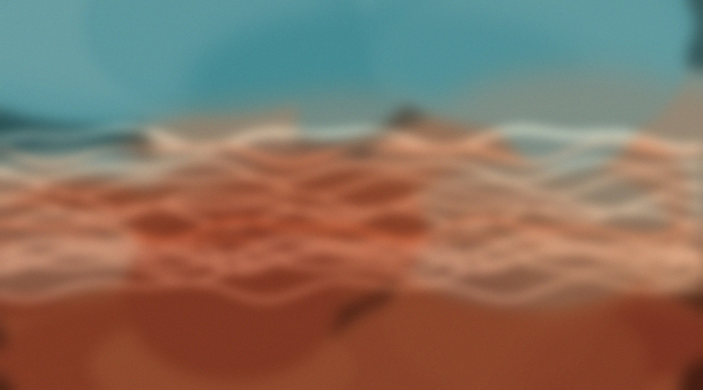 Foto sfocata di onde oceaniche in movimento sotto un cielo blu.