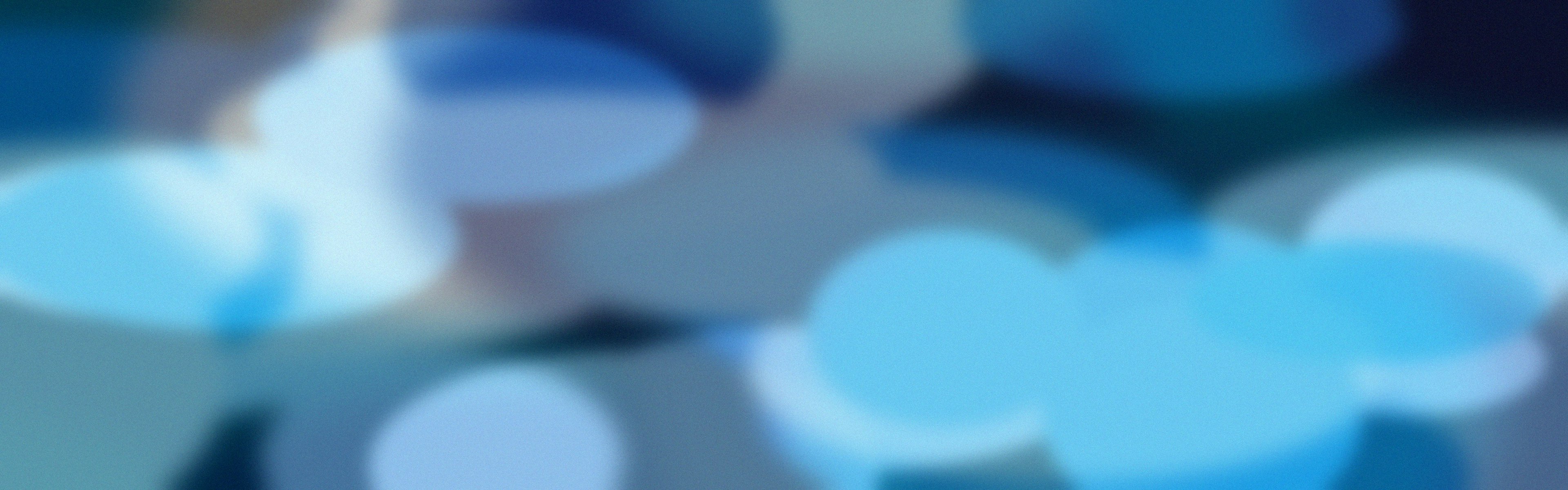 Blurry blue and white circular bokeh lights on a dark background.