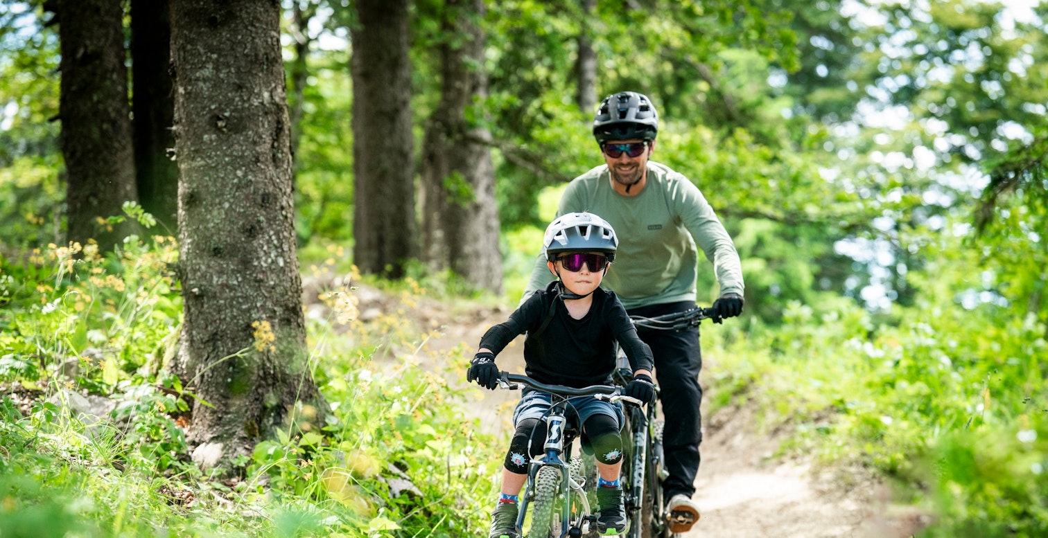Famille sur les pistes de VTT de Métabief dans la forêt