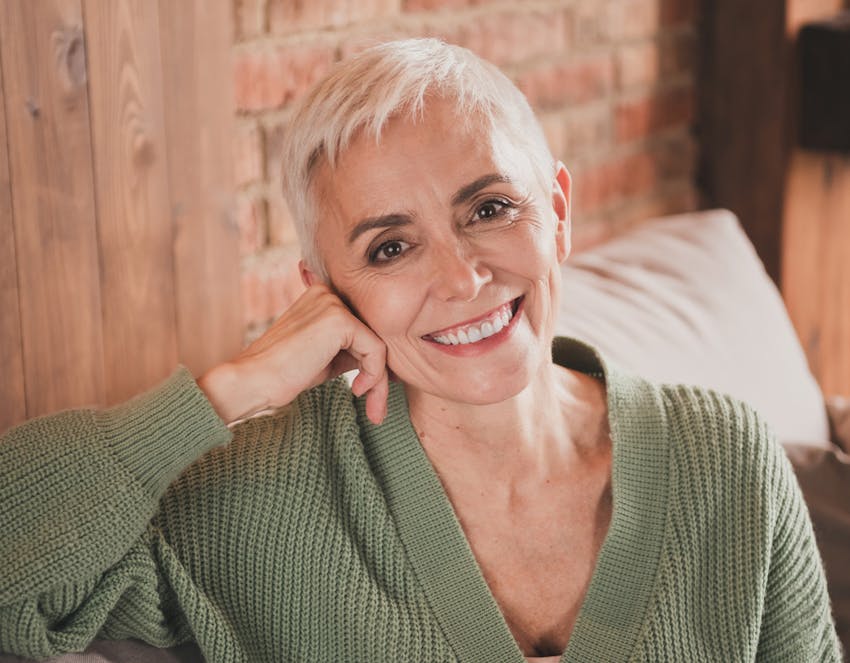 woman smiling and resting her head on her hand