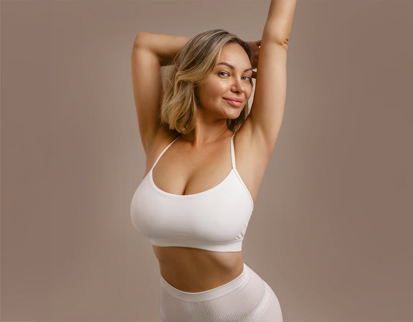 A woman posing with her hands above her head