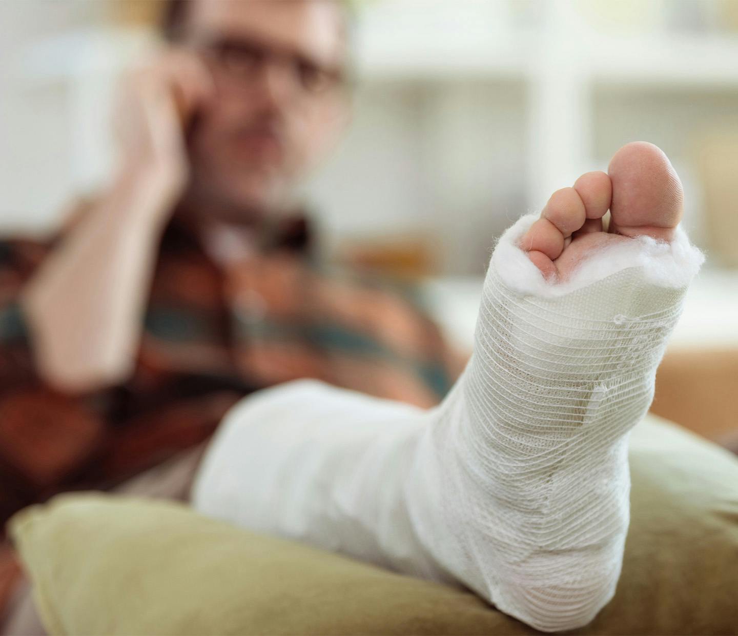 man with broken foot propped up on a pillow