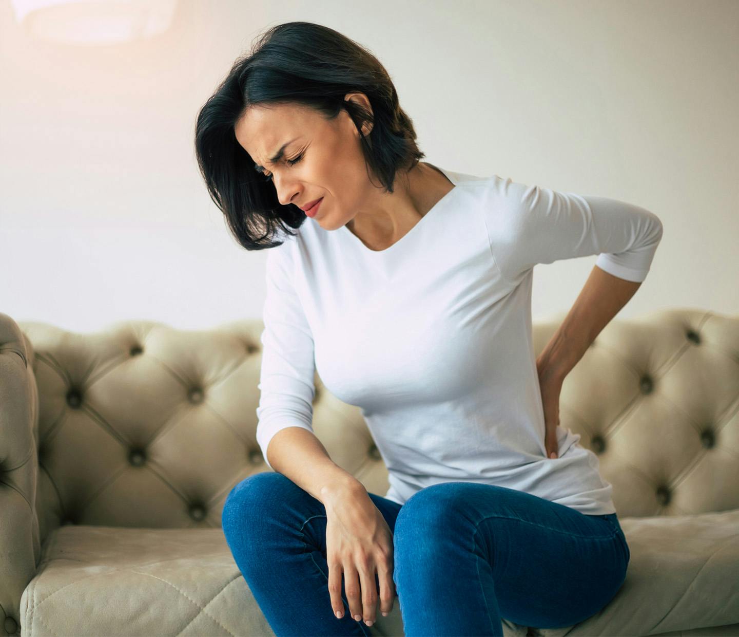 woman holding her lower back in pain