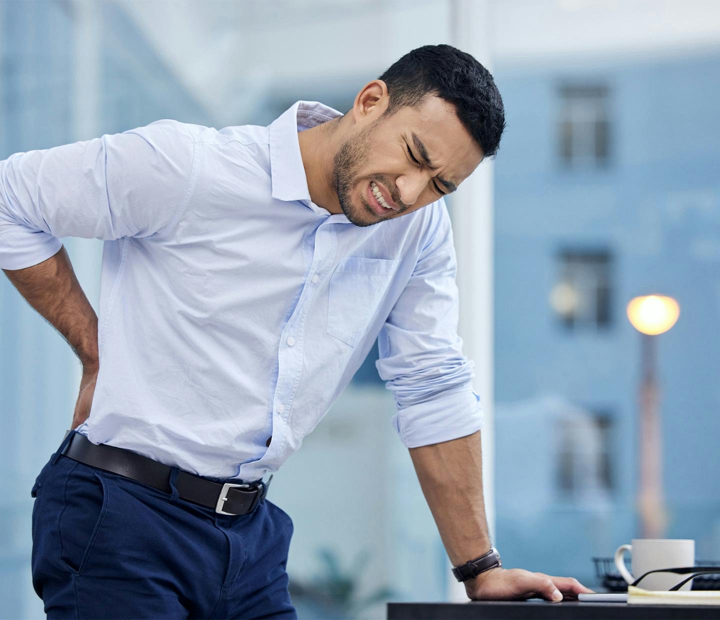 man holding his lower back in pain