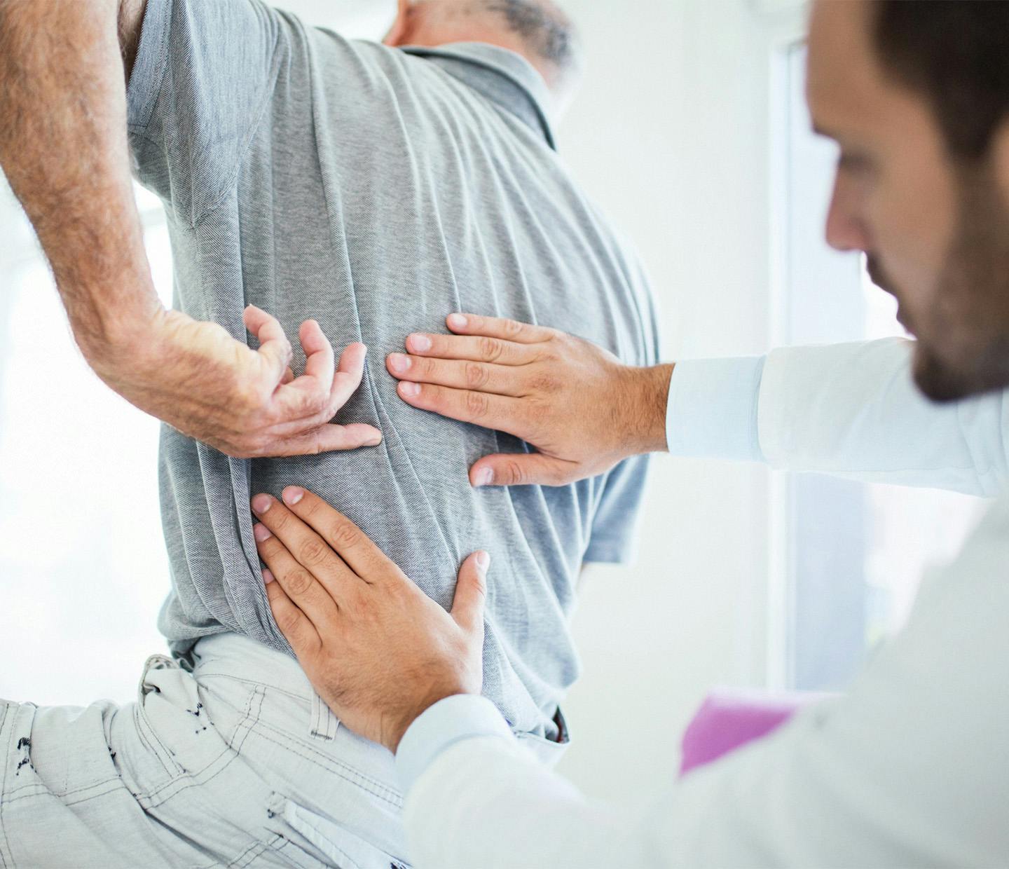 doctor examining a man's back