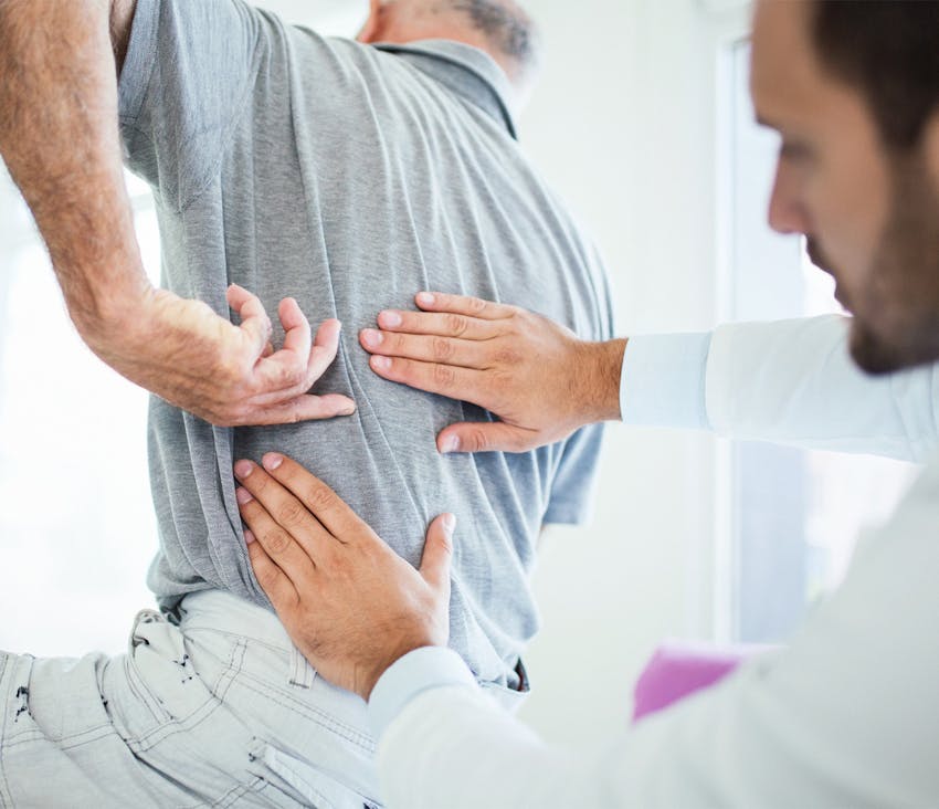 doctor examining a man's back
