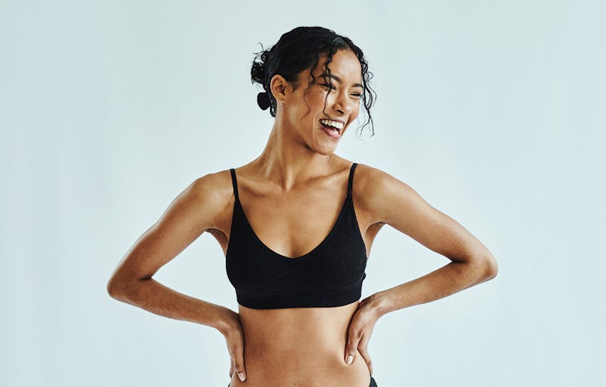 woman smiling looking to the side with hand on hips