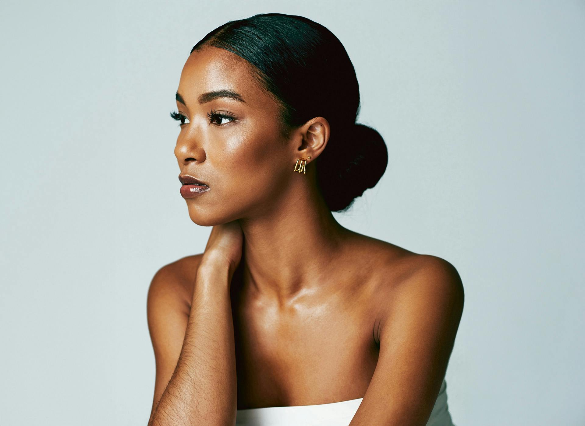 woman looking to the side with hand on neck