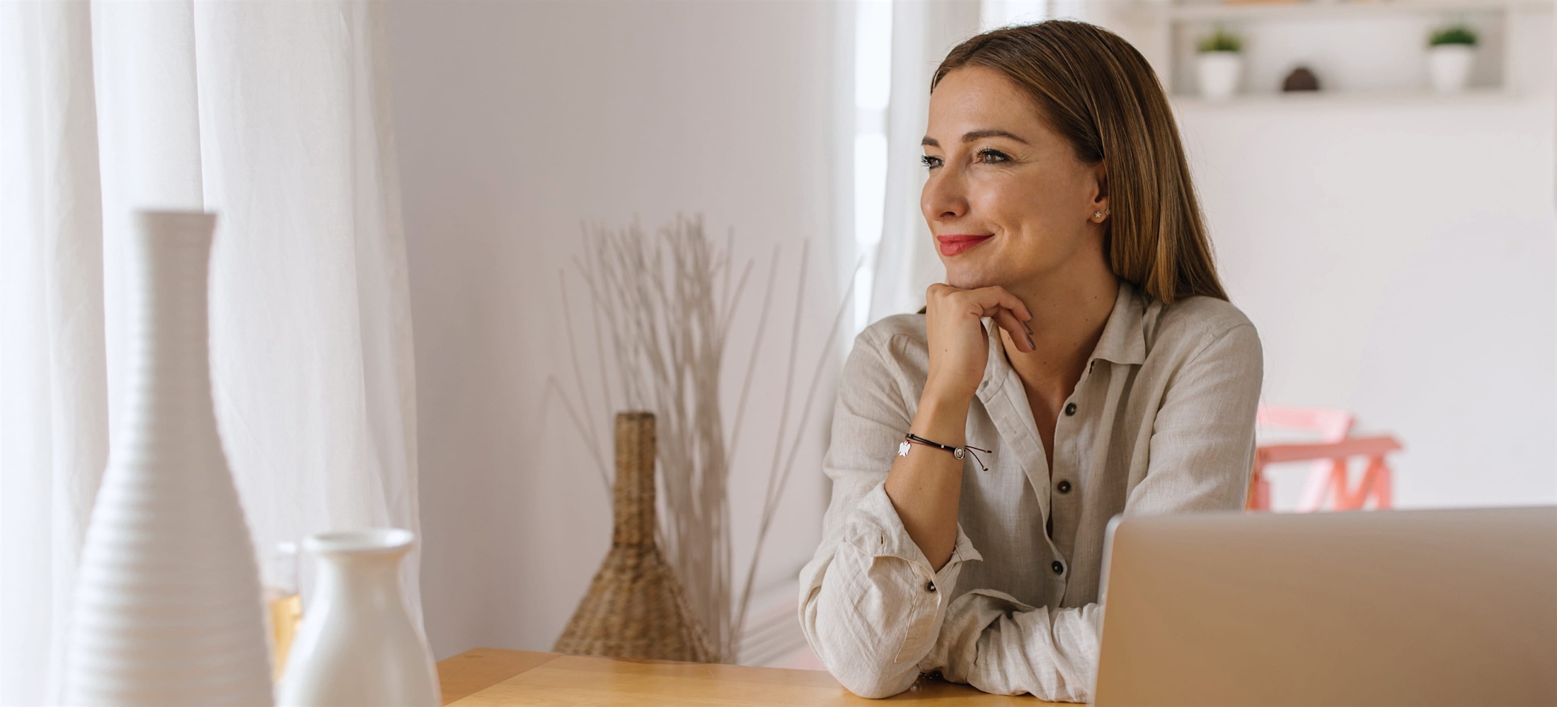 Woman sitting at a table resting her chin on her hand