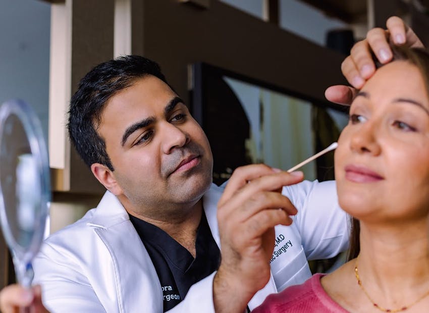 Dr. Chopra looking at client's eye