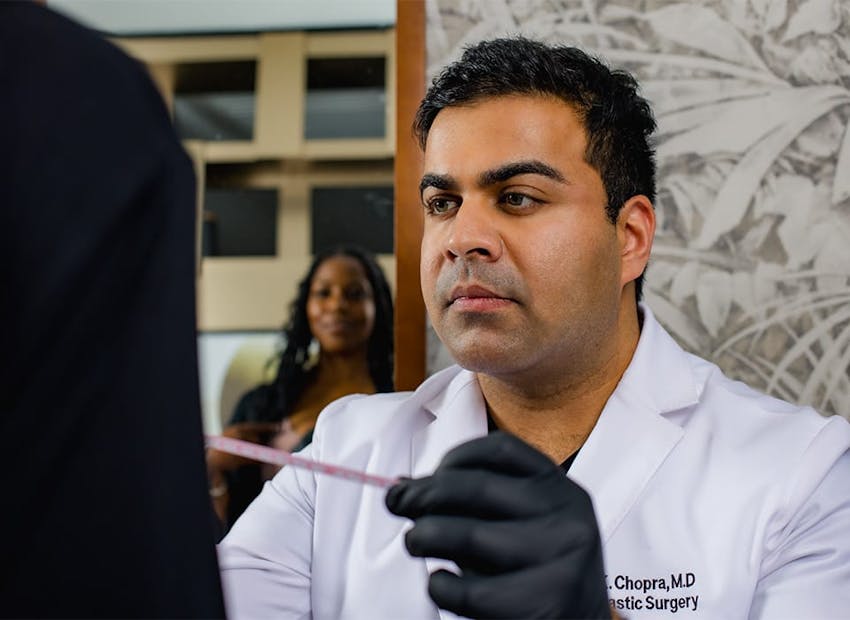 Dr. Chopra looking at patient while her looks in mirror