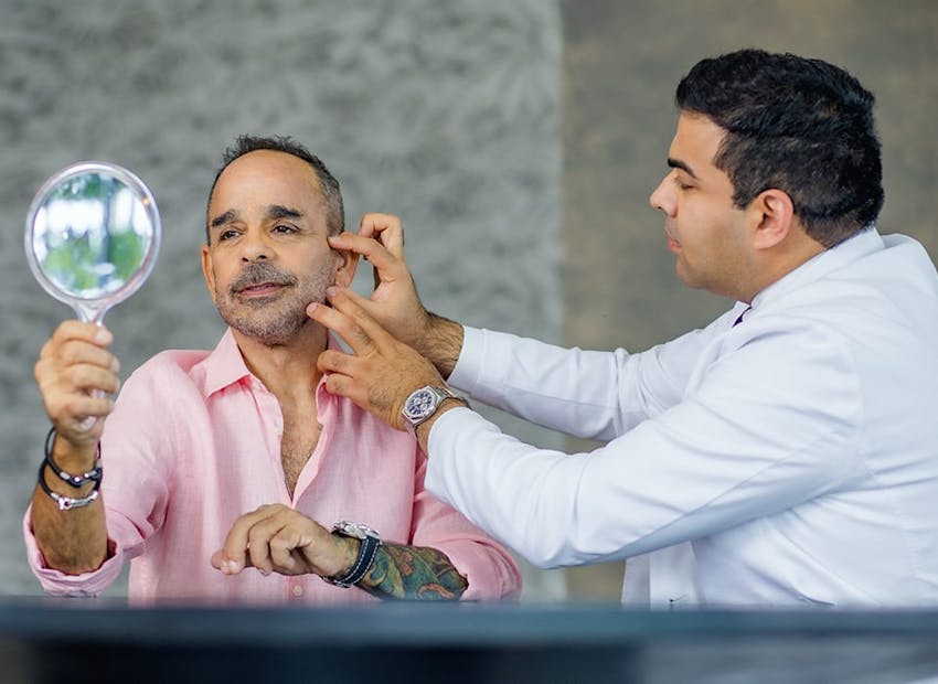 Dr. Chopra touching patient's jaw and cheek