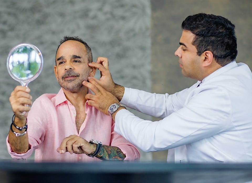 Dr. Chopra touching patient's jaw and cheek