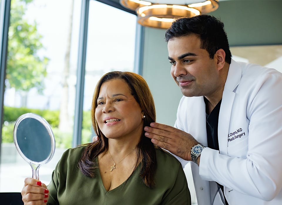 Dr. Chopra with patient looking in mirror