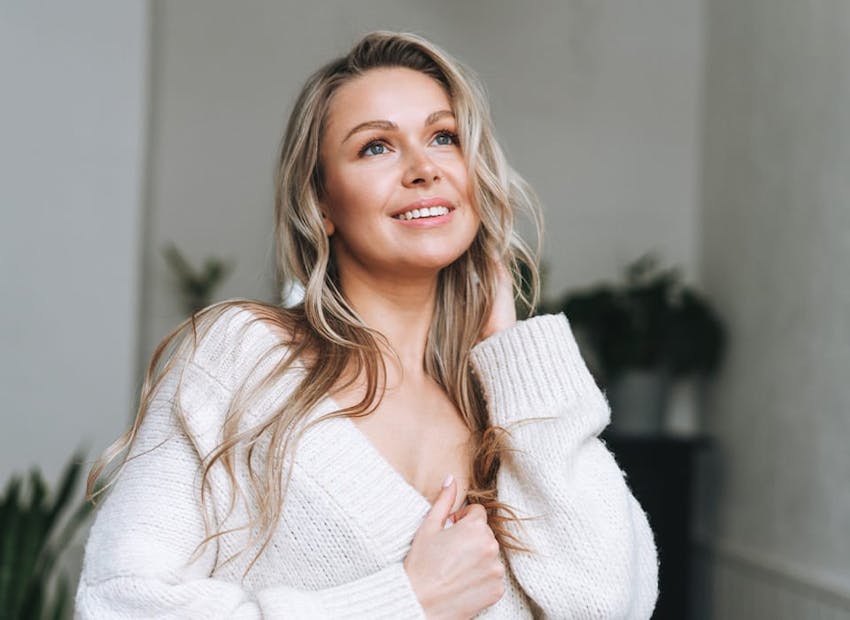 woman in white cardigan looking upwards