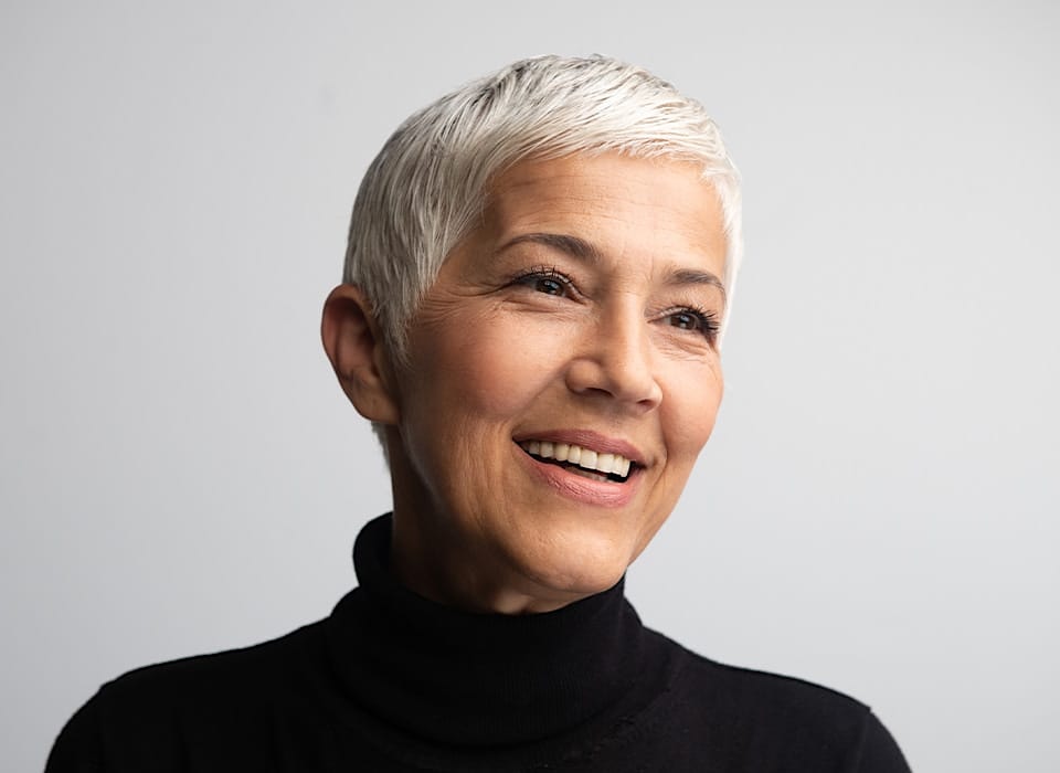 woman with short grey hair in black turtleneck