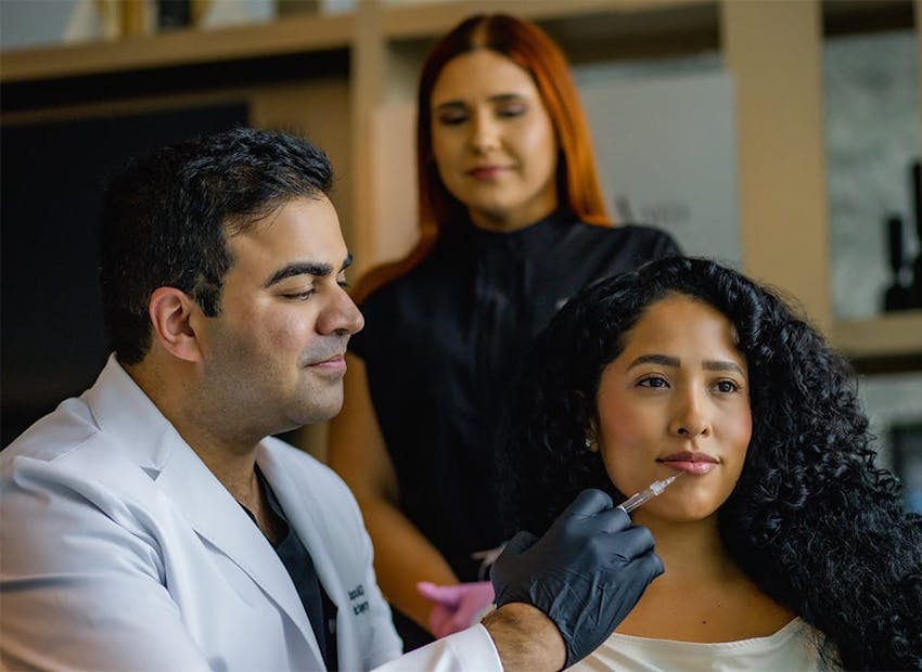 Dr. Chopra injecting into patient's lip