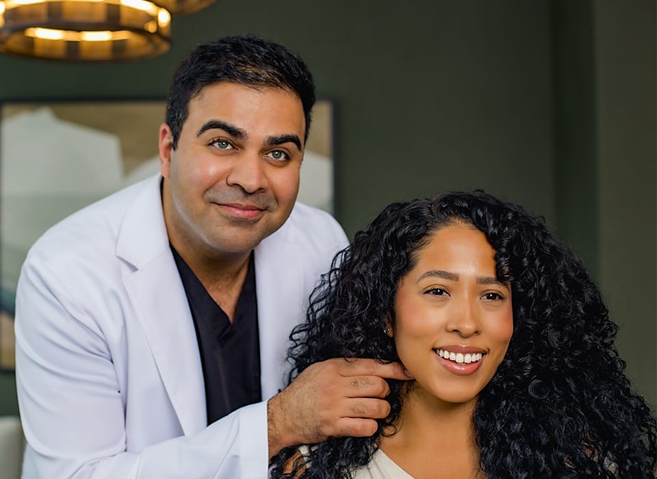 Dr. Chopra pointing at patient's neck