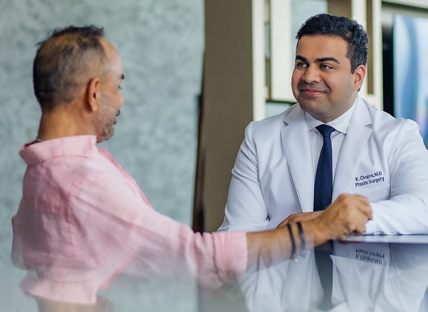 Dr. Chopra sitting with patient