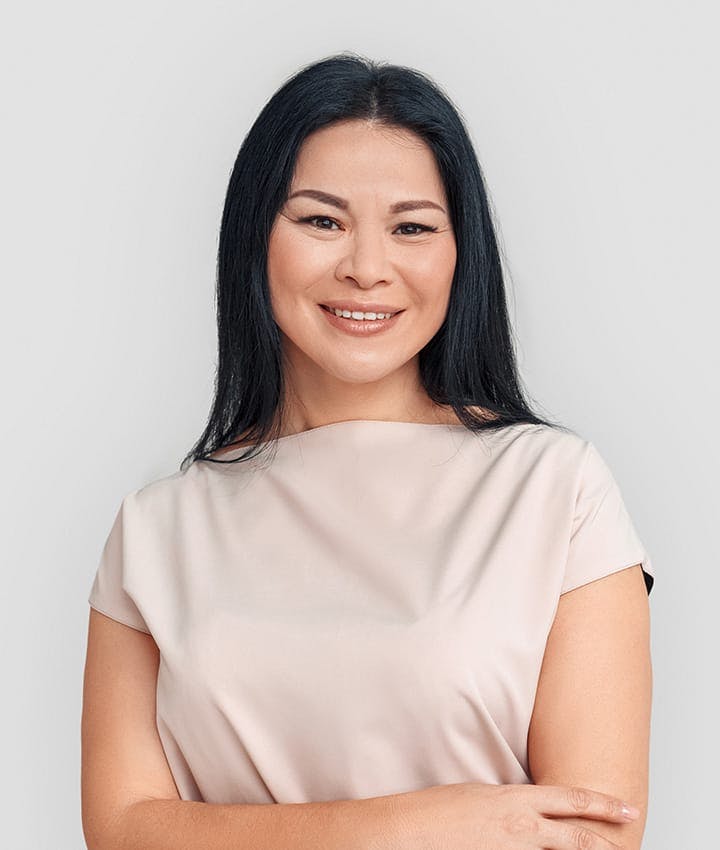 woman smiling with hands touching her elbows