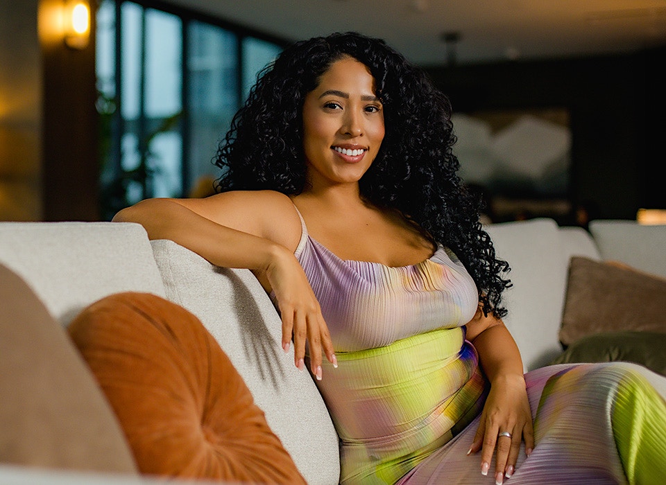 woman with curly hair wearing a colorful dress