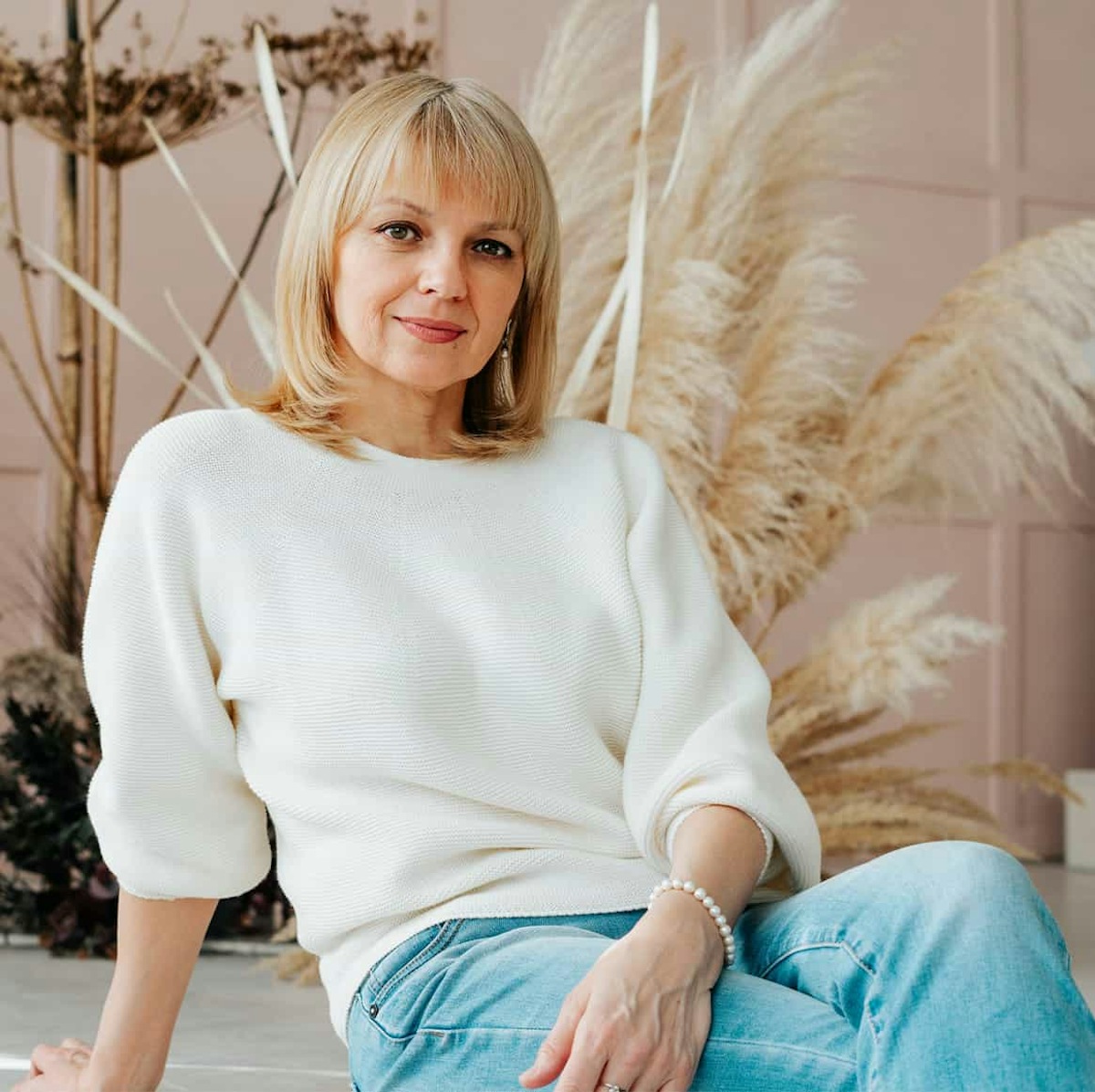 woman in a white sweater and blue jeans