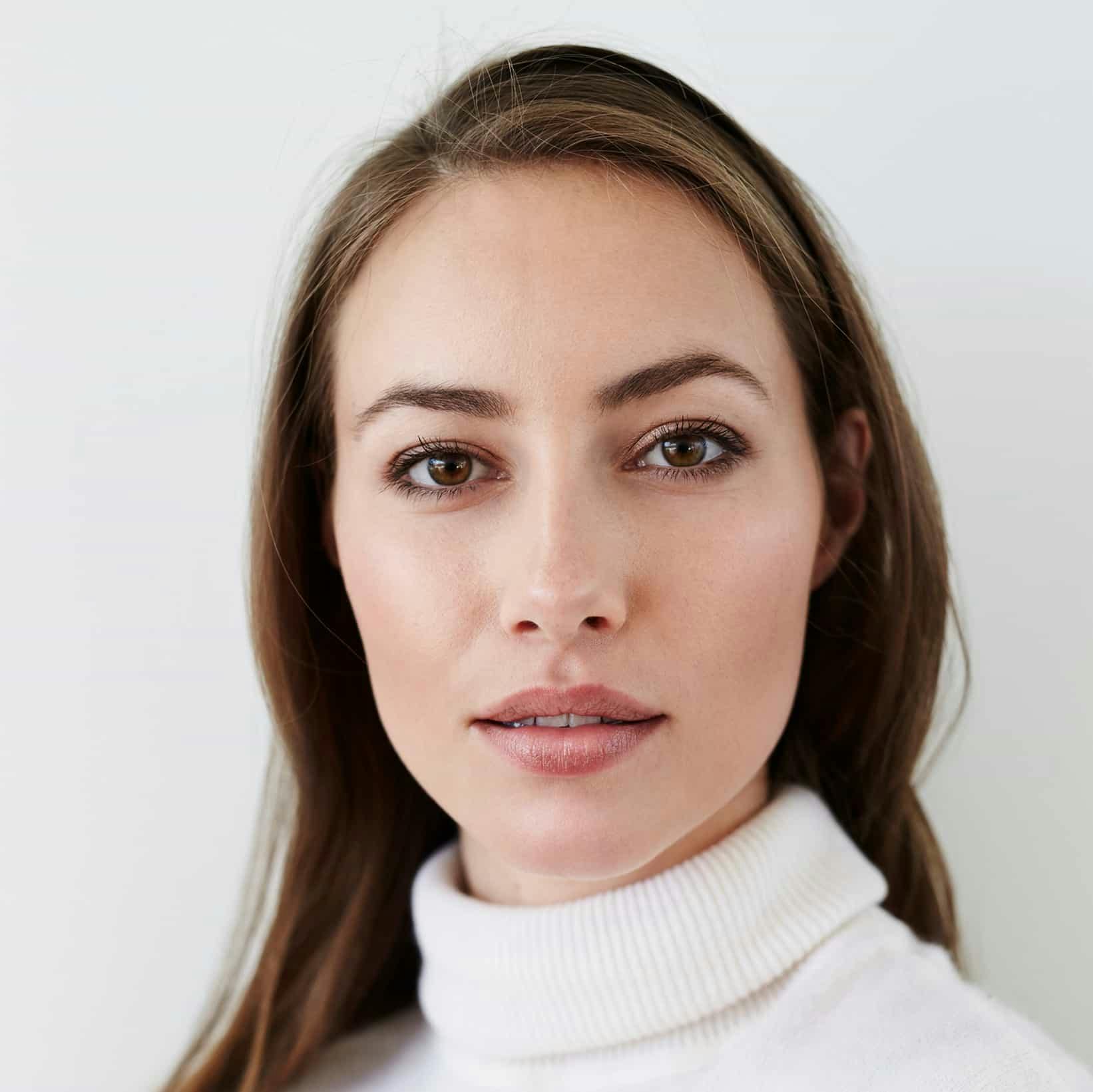 woman in white turtleneck looking at the camera