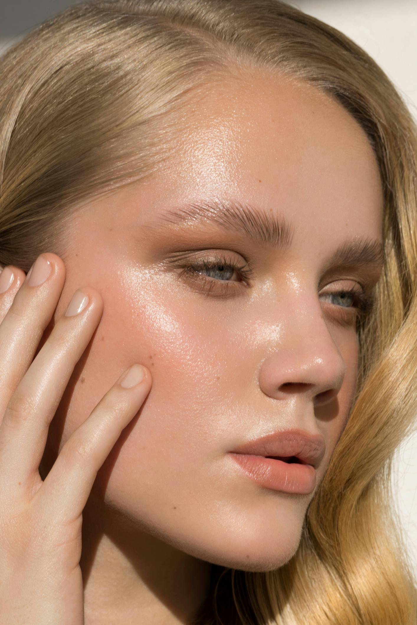 beautiful young woman with smooth skin looks away from the camera. Her glowing skin emulate the potential results of SkinPen® Microneedling