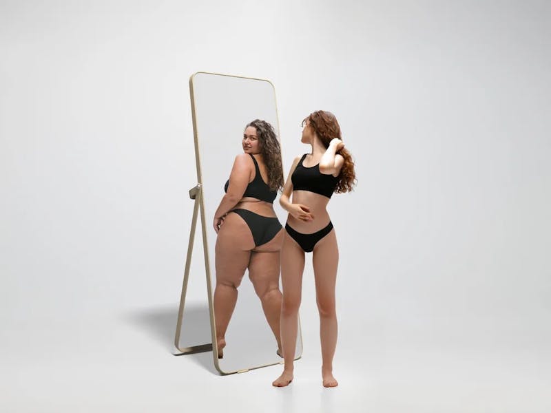 woman looking at altered appearance in mirror