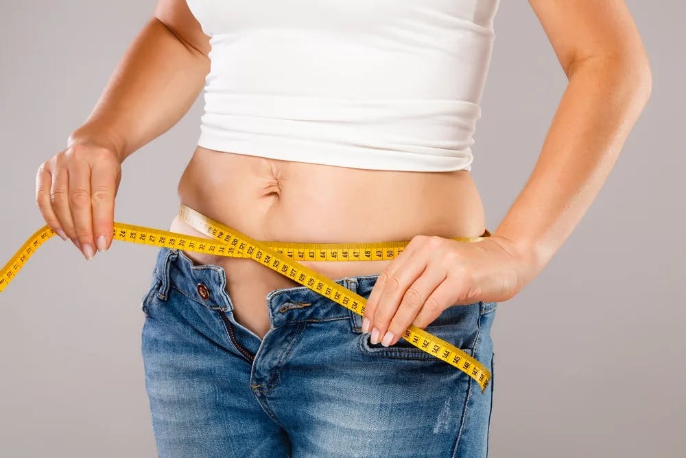 woman with tape measure around waist