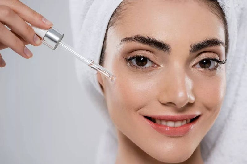 woman using hyaluronic acid on her face
