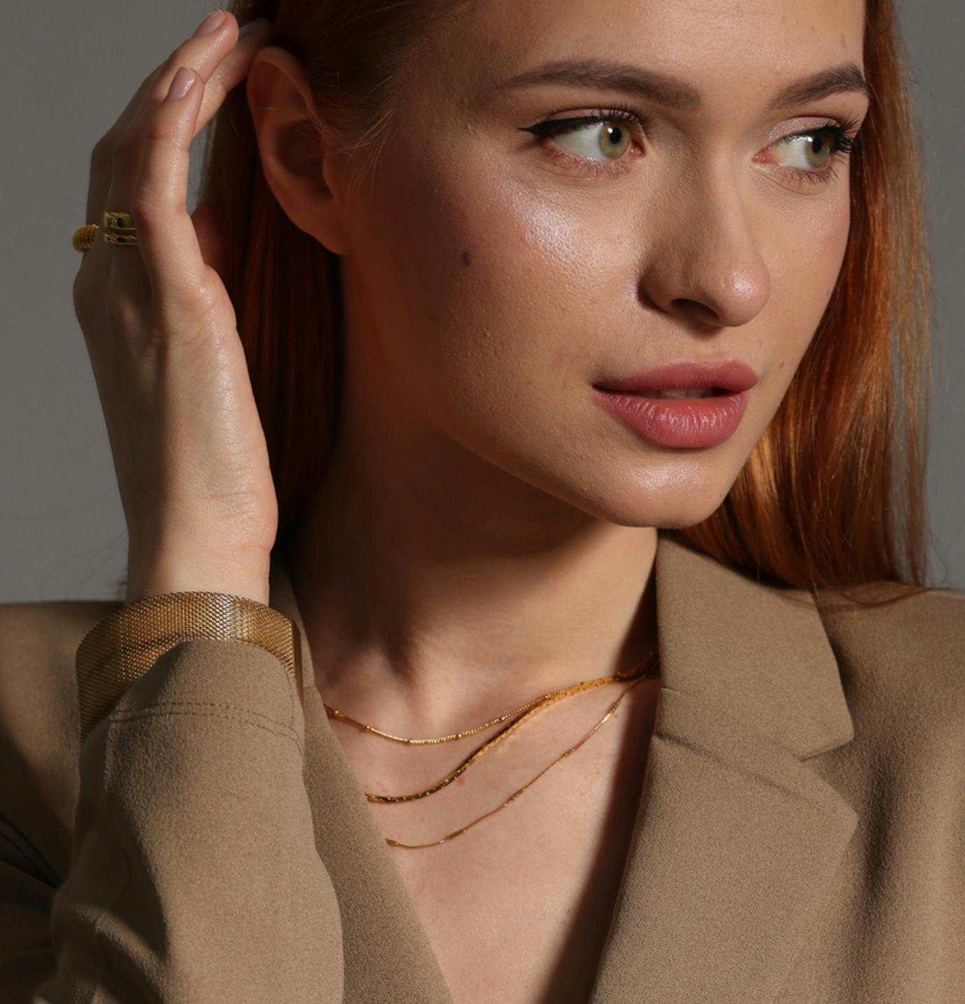 red headed woman touching her ear
