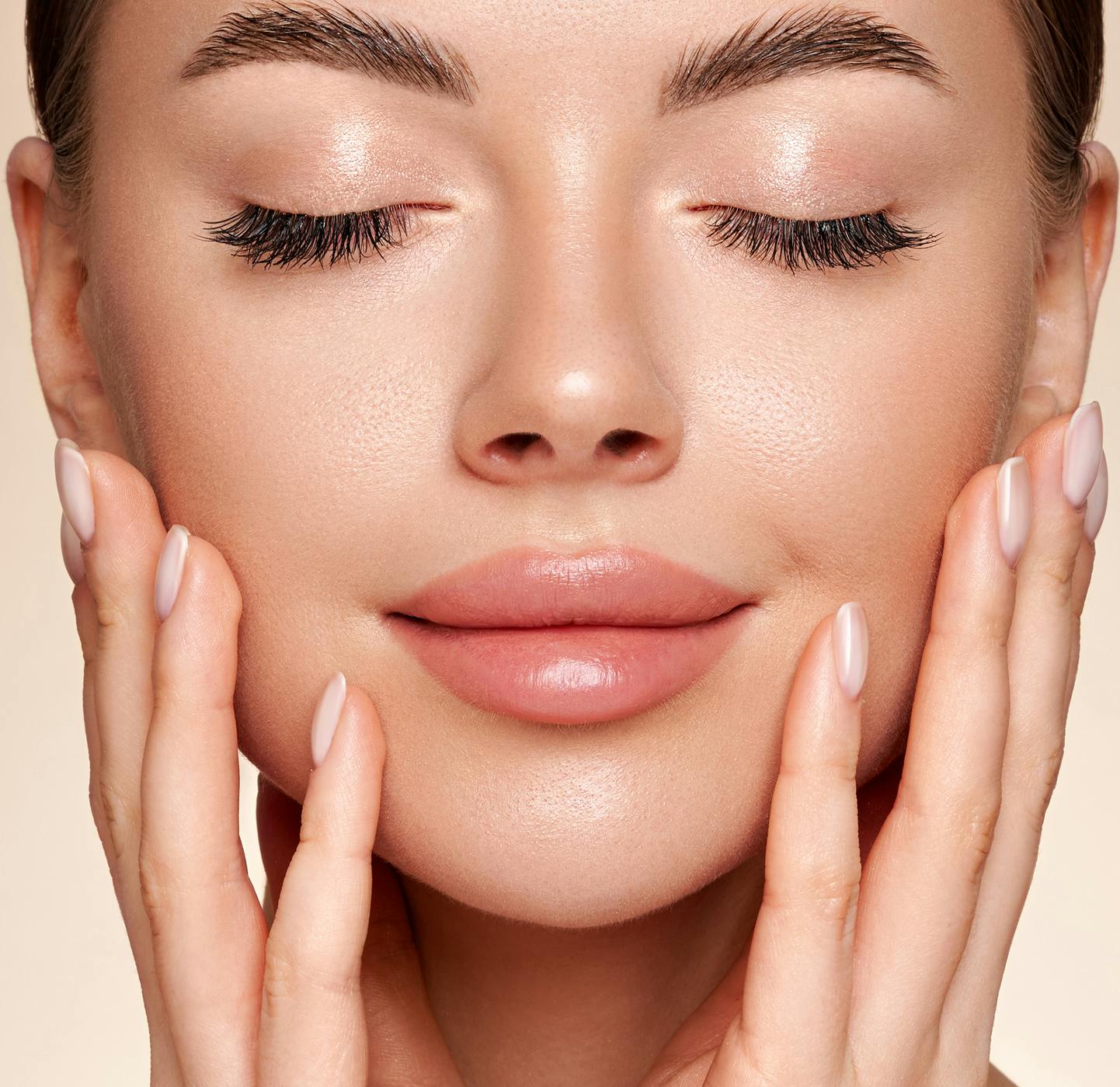 A woman touching her face with her eyes closed