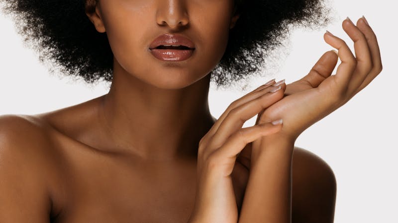 Lower half of woman touching her hands