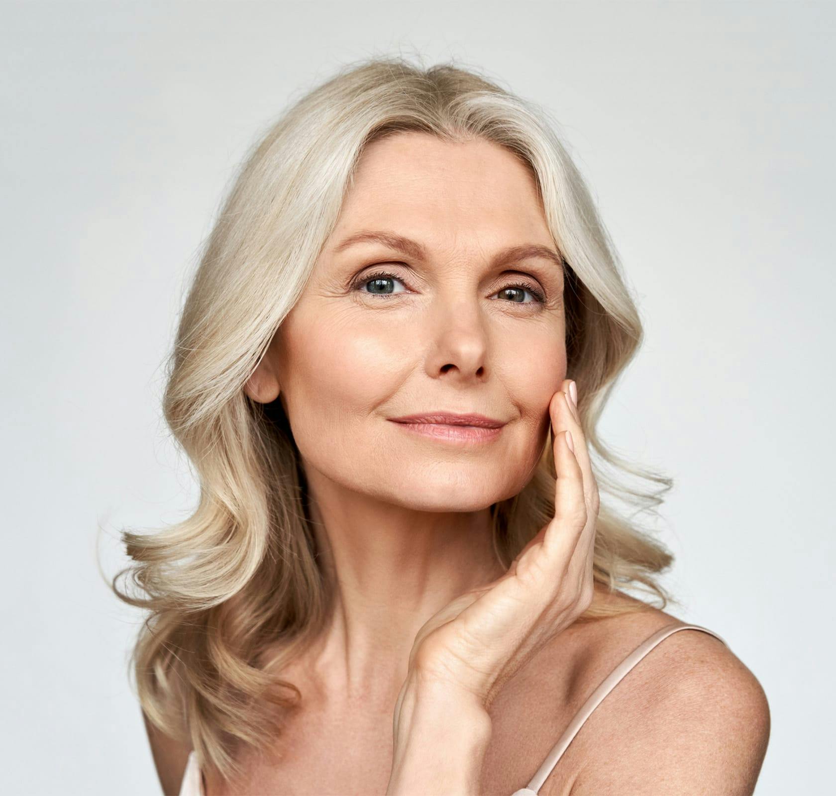 older woman touching her face