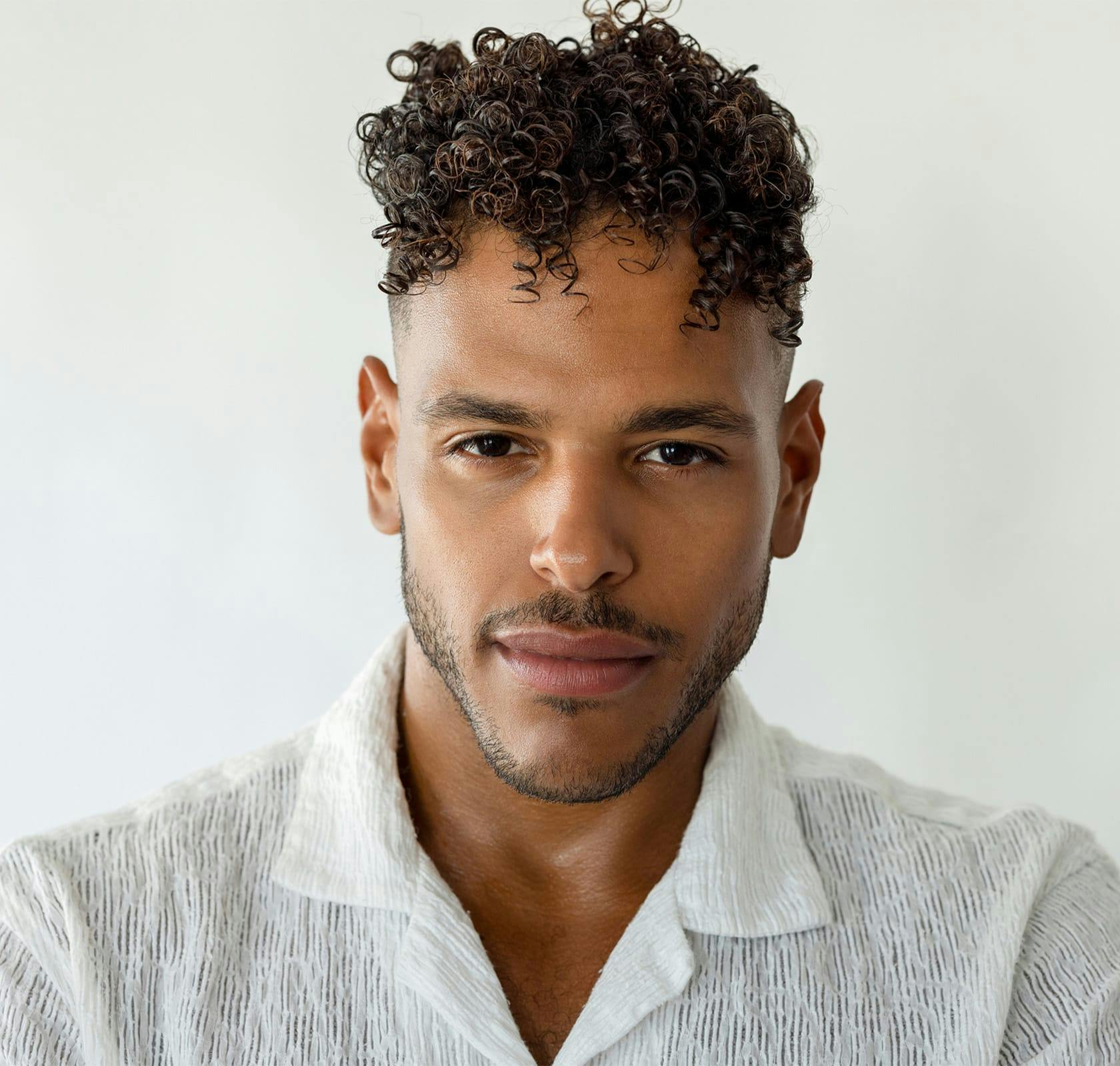 curly haired man smiling
