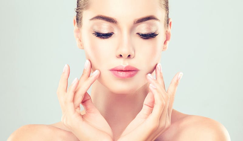 woman touching her cheeks