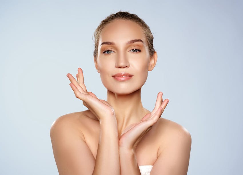 Woman smiling with her hands near her face