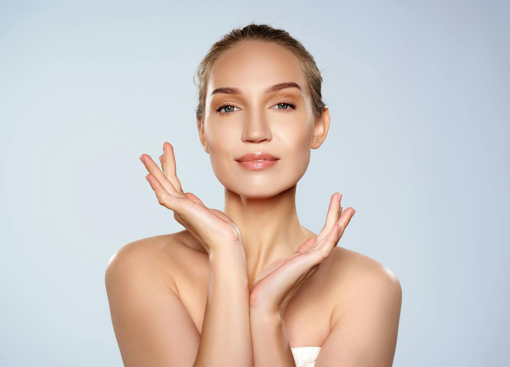 Woman smiling with her hands near her face