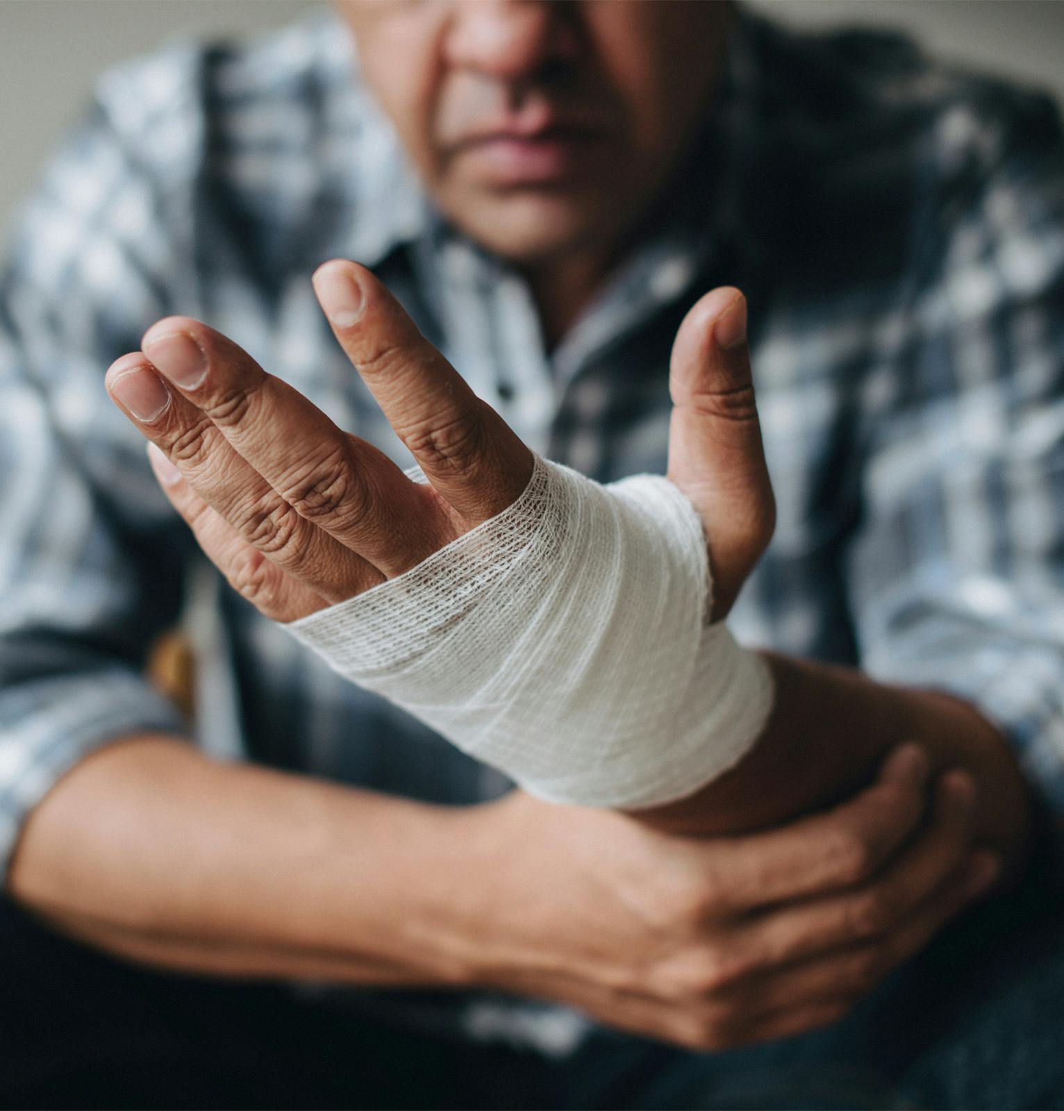 man holding his hand wrapped in gauze