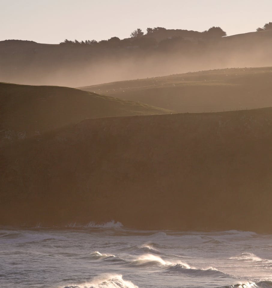 misty hills next to ocean